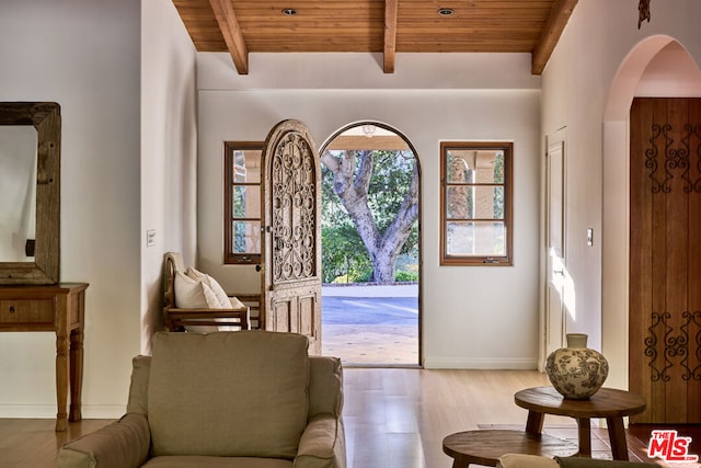 entryway featuring beam ceiling, wood-type flooring, and wooden ceiling