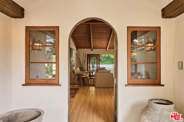 hall featuring lofted ceiling, light hardwood / wood-style flooring, and wooden ceiling