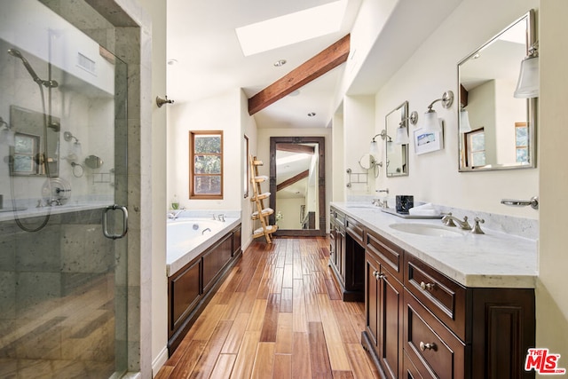 bathroom with hardwood / wood-style floors, vanity, lofted ceiling with skylight, and independent shower and bath