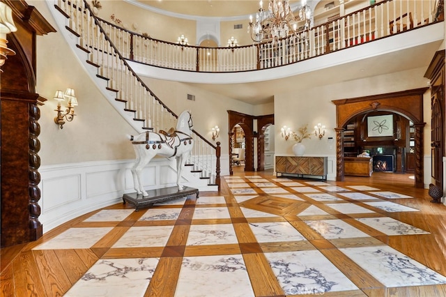 foyer entrance with a chandelier, a high ceiling, and wood-type flooring