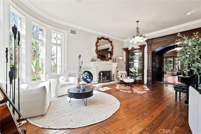 living room with ornamental molding, dark wood-type flooring, and a chandelier