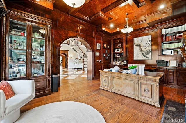 office space featuring wood walls, light hardwood / wood-style flooring, beamed ceiling, and coffered ceiling