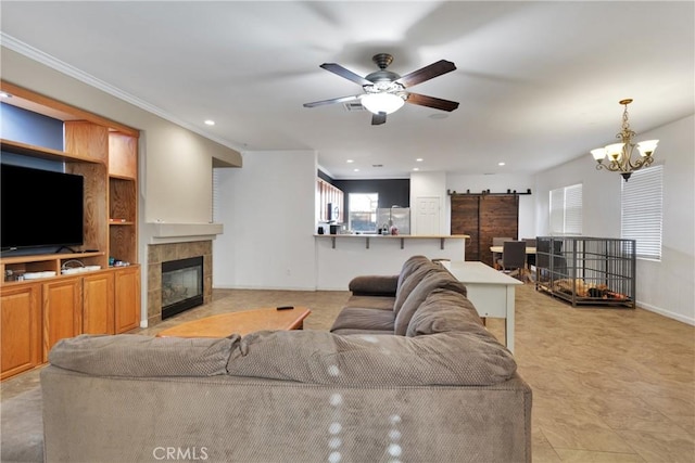 living room with a tiled fireplace and ceiling fan with notable chandelier