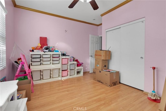 playroom featuring ceiling fan, ornamental molding, and light wood-type flooring