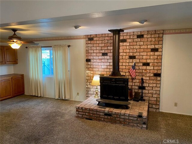 unfurnished living room with carpet flooring and a wood stove