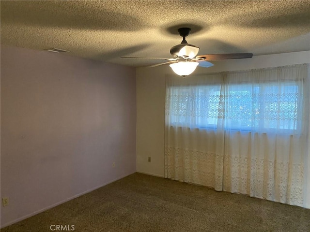 empty room with a textured ceiling, carpet floors, and ceiling fan