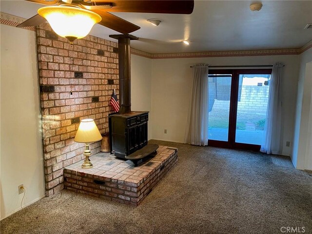 carpeted living room with a wood stove and ornamental molding