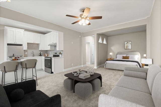 carpeted bedroom featuring ceiling fan, white fridge, and sink