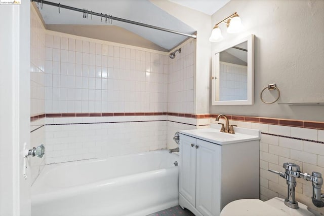 full bathroom with vanity, tiled shower / bath combo, tile walls, toilet, and lofted ceiling