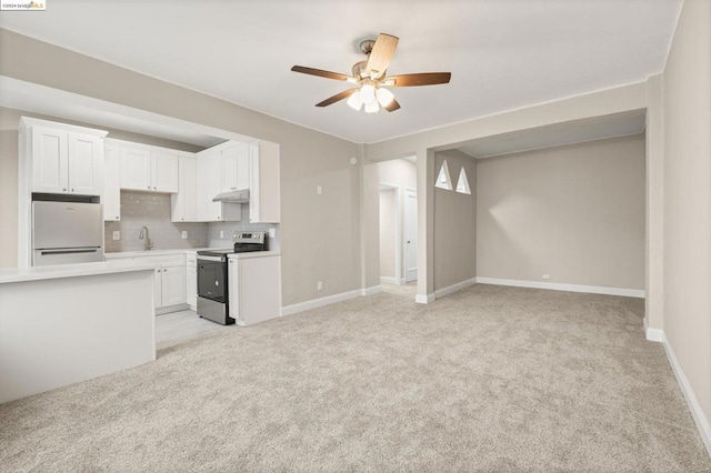 kitchen with electric range, white fridge, light colored carpet, and white cabinetry