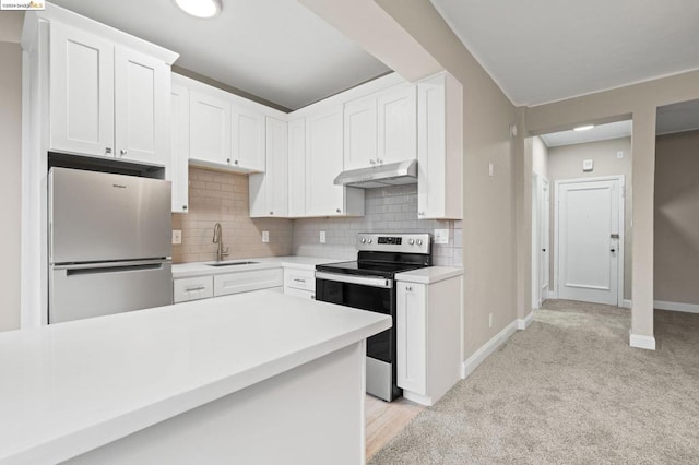 kitchen featuring decorative backsplash, light carpet, stainless steel appliances, sink, and white cabinets