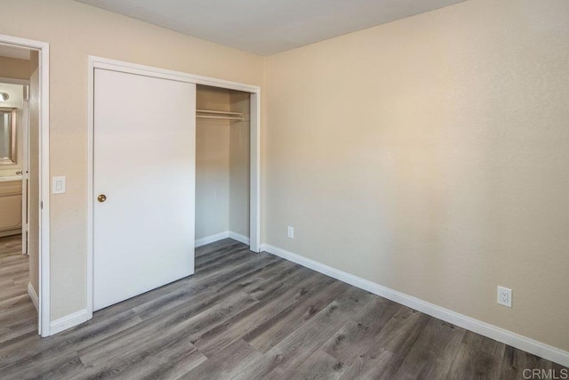 unfurnished bedroom featuring a closet and dark hardwood / wood-style floors