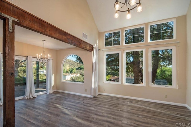 interior space featuring high vaulted ceiling, dark hardwood / wood-style floors, and an inviting chandelier