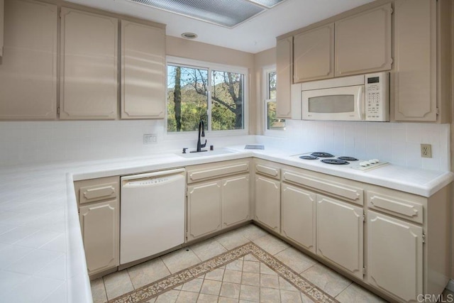 kitchen with light tile patterned floors, sink, white appliances, and backsplash