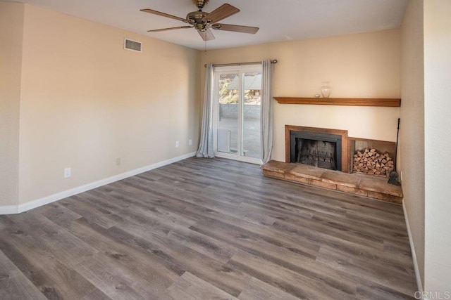 unfurnished living room featuring ceiling fan, dark hardwood / wood-style flooring, and a fireplace