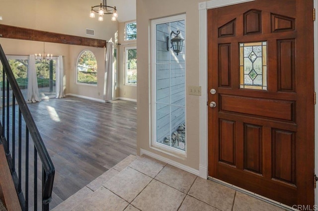 tiled entryway featuring a chandelier