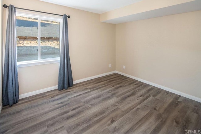 empty room featuring a wealth of natural light and dark hardwood / wood-style floors