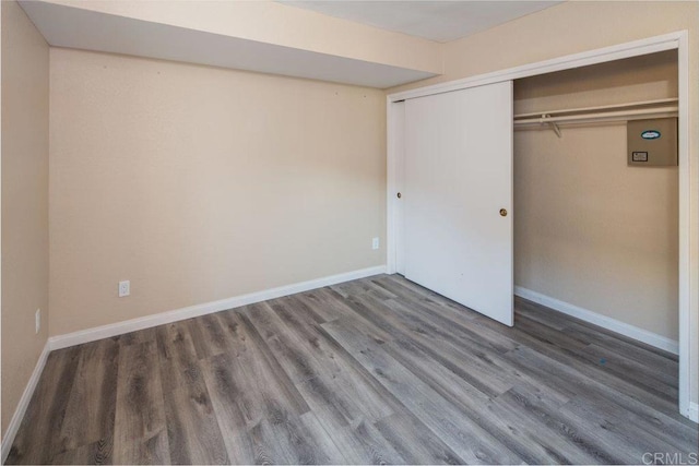 unfurnished bedroom with dark wood-type flooring and a closet