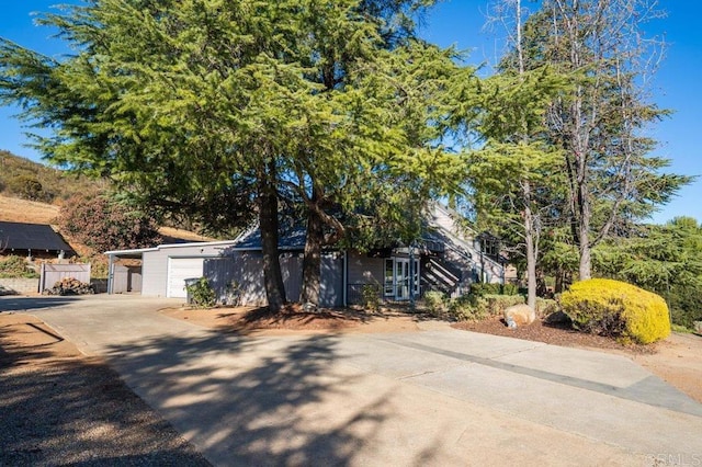 view of property hidden behind natural elements featuring a garage