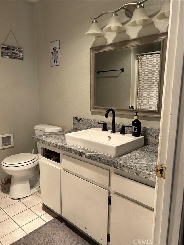 bathroom with tile patterned flooring, vanity, and toilet