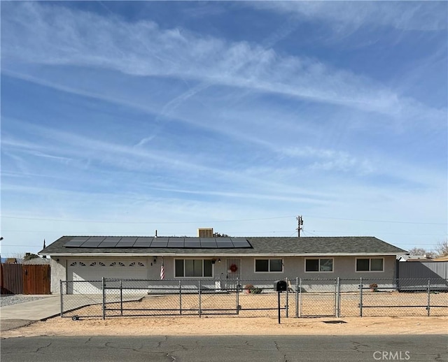 single story home featuring solar panels and a garage