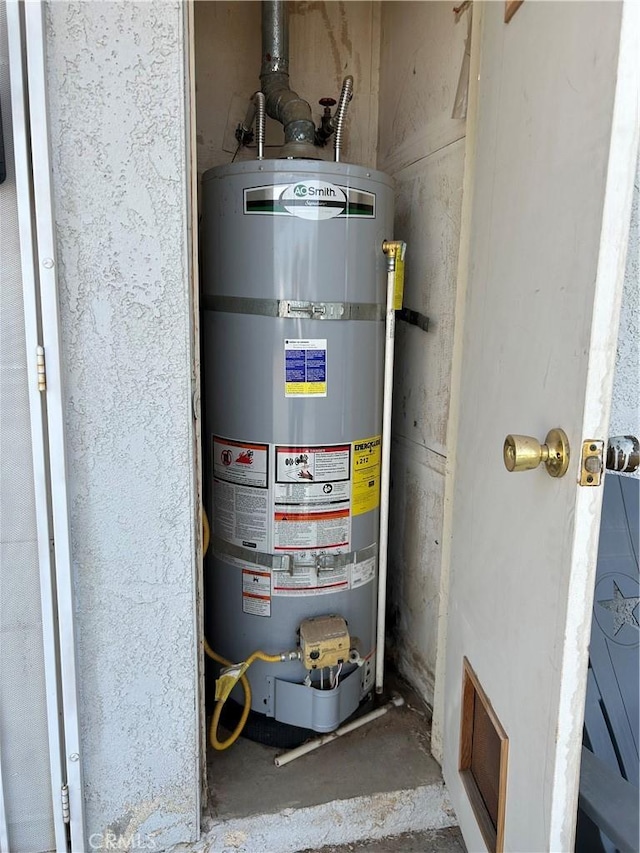 utility room featuring strapped water heater