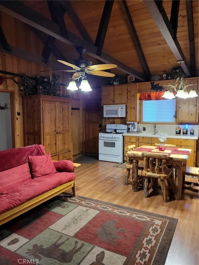 living room with wooden walls, ceiling fan, light wood-type flooring, beamed ceiling, and wood ceiling