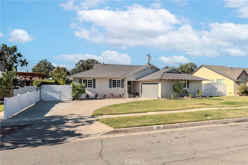 ranch-style house featuring a garage and a front lawn