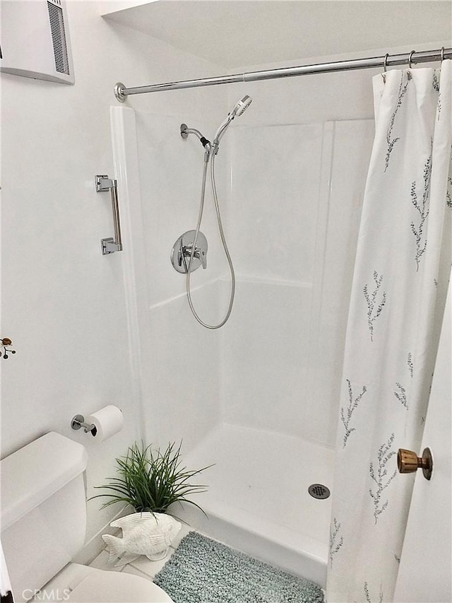 bathroom featuring curtained shower and toilet