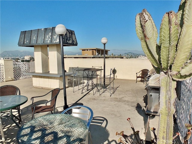 view of patio featuring a bar, area for grilling, and a mountain view