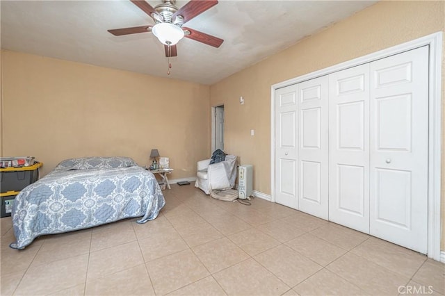 bedroom featuring ceiling fan, a closet, and light tile patterned floors