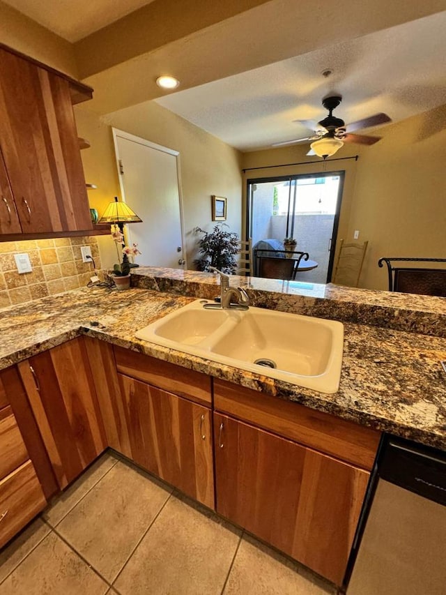 kitchen featuring ceiling fan, dishwasher, sink, decorative backsplash, and light tile patterned floors