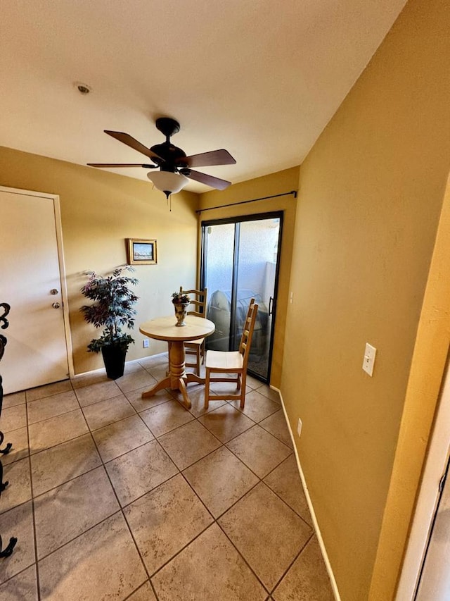 tiled dining space featuring ceiling fan