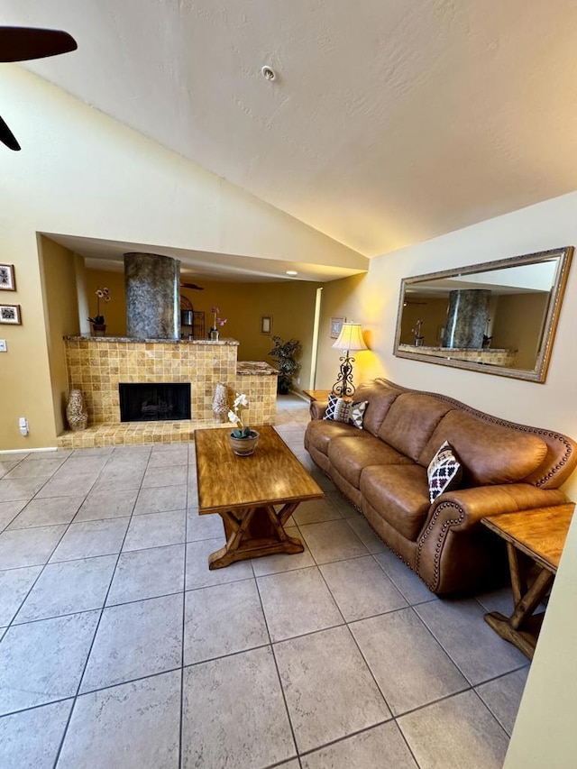 living room with ceiling fan, light tile patterned flooring, lofted ceiling, and a fireplace