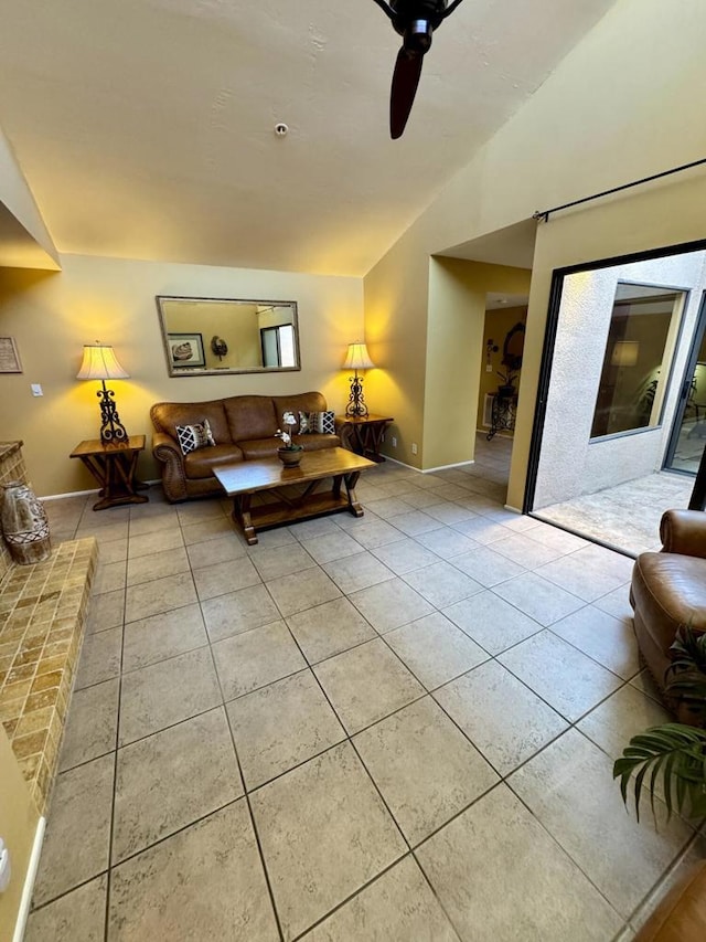 tiled living room with ceiling fan and vaulted ceiling