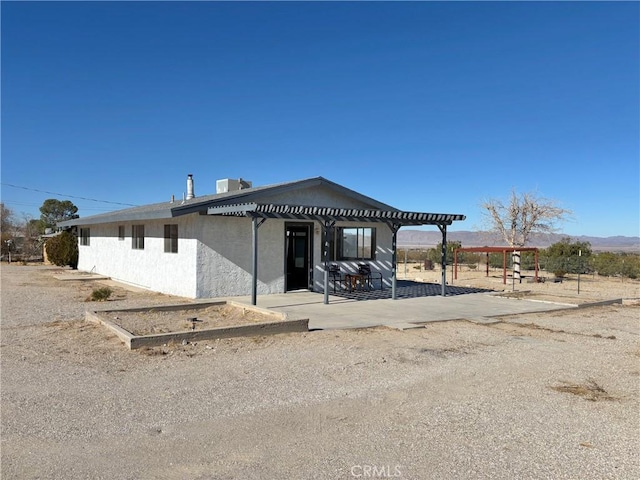 view of front of property featuring a pergola and a patio