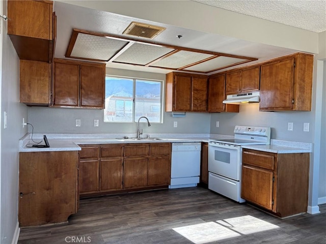 kitchen featuring sink, dark wood-type flooring, a textured ceiling, and white appliances