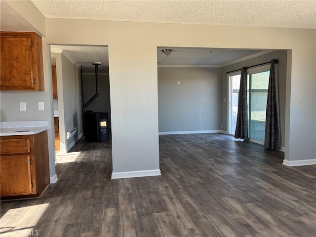 kitchen featuring crown molding, dark hardwood / wood-style floors, and a textured ceiling