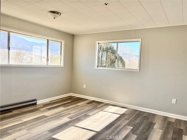 spare room with wood-type flooring and baseboard heating