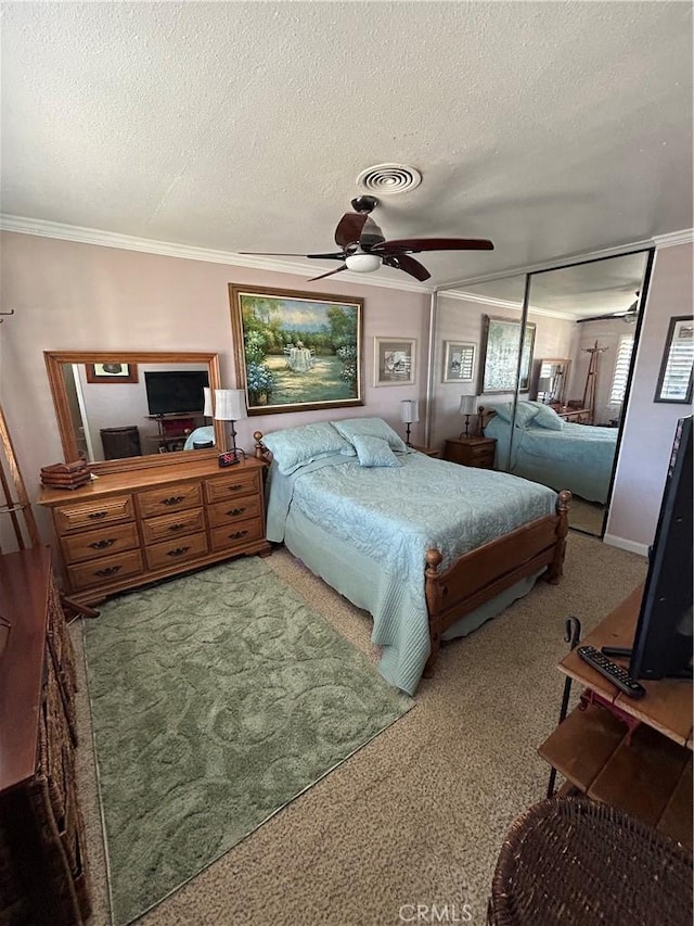 bedroom with ceiling fan, crown molding, a textured ceiling, and carpet