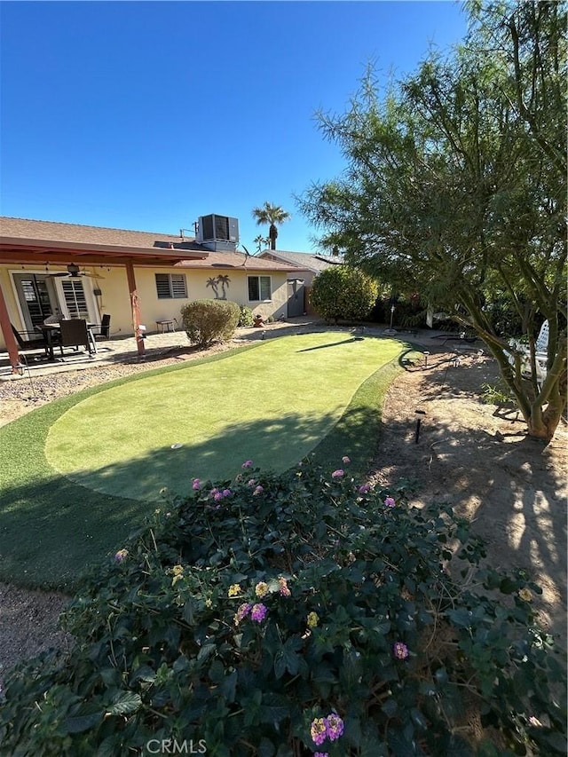 view of yard with central AC and a patio