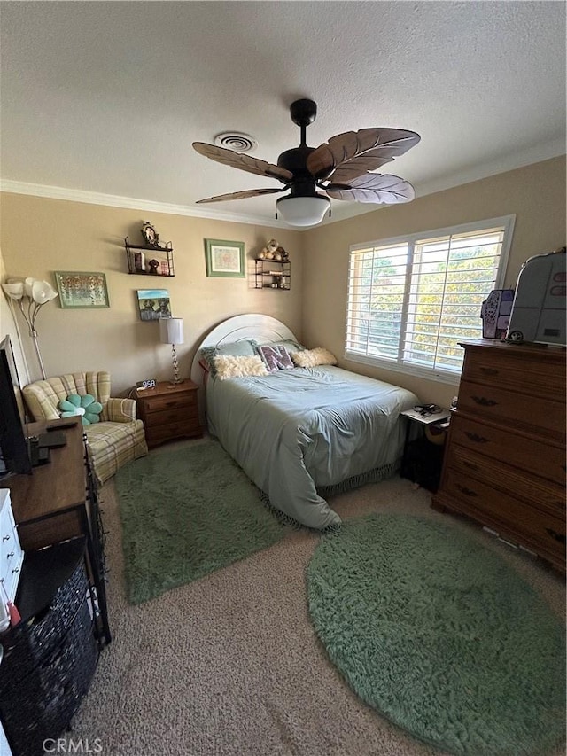 bedroom featuring ornamental molding, carpet flooring, ceiling fan, and a textured ceiling