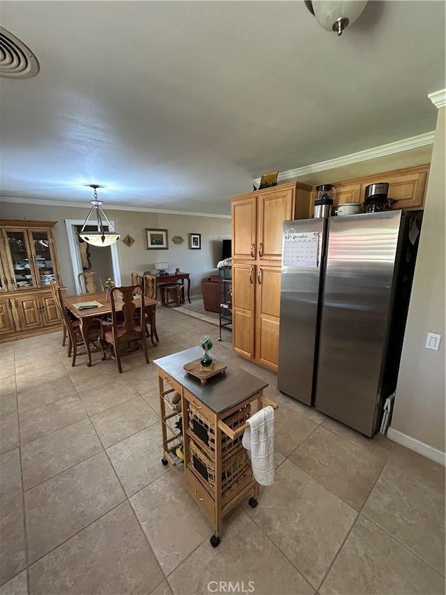 kitchen featuring hanging light fixtures, ornamental molding, light tile patterned floors, and stainless steel fridge