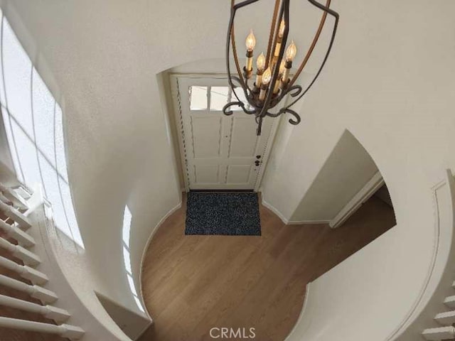 foyer entrance featuring hardwood / wood-style floors and an inviting chandelier