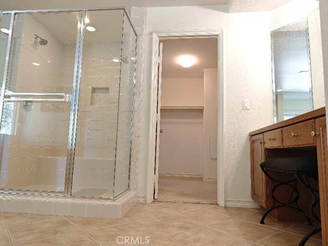 bathroom with tile patterned flooring and a shower with shower door