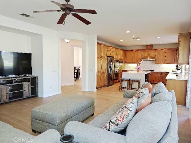 living room featuring ceiling fan and light wood-type flooring