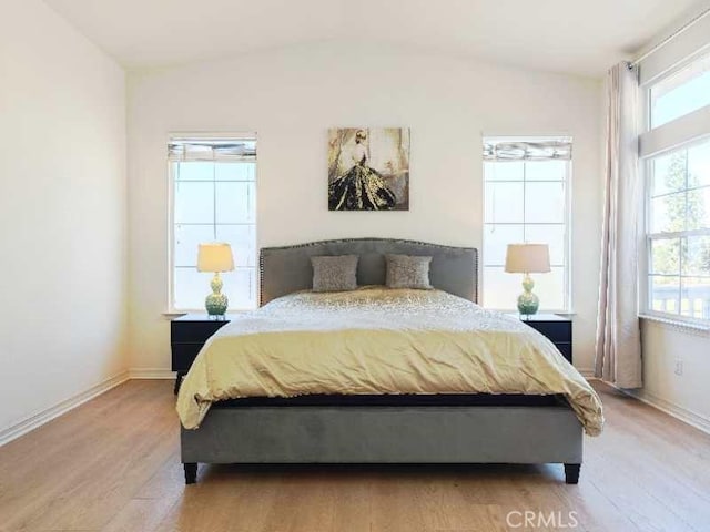 bedroom featuring light hardwood / wood-style floors and vaulted ceiling