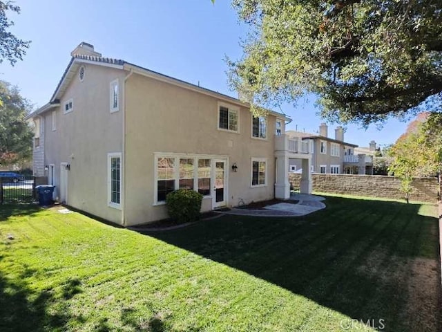 rear view of property featuring a lawn