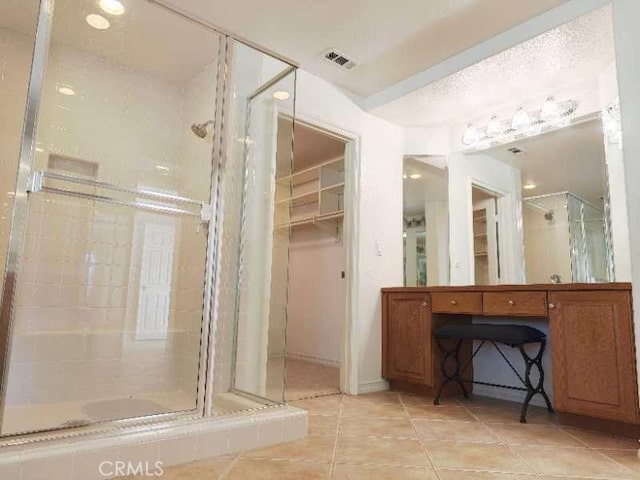 bathroom with tile patterned floors and a shower with door