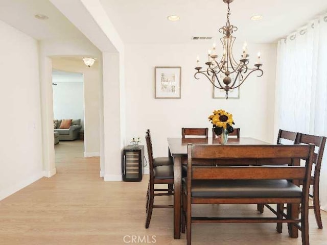 dining space featuring light hardwood / wood-style floors and a notable chandelier